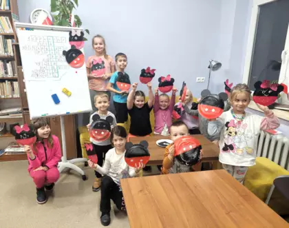 Grupowe zdjęcie. Dzieci pokazują swoje prace plastyczne.