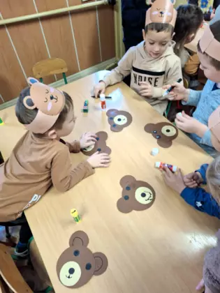 Chłopcy robią buźkę misia. Praca plastyczna.