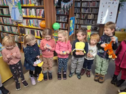 Dzieci stoją w kole. W ręce trzymają bajkową maskotkę.