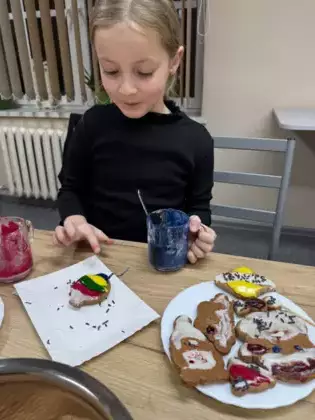 Dziewczynka lukruje pierniki.