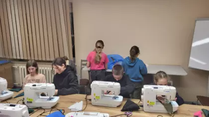 Uczestnicy warsztatów w trakcie szycia choinek.