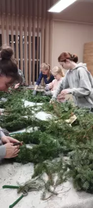 Uczestnicy warsztatów  w trakcie wiązania gałązek.