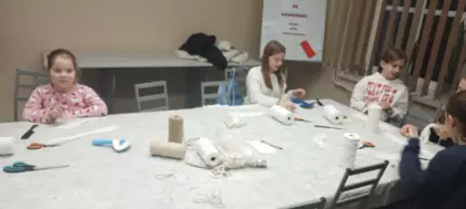 Uczestnicy wykonują aniołki ze sznurka.