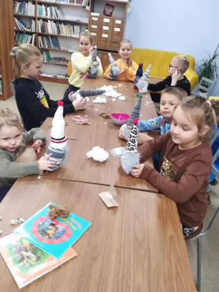 Dzieci na zajęciach w bibliotece szyją skrzaty.