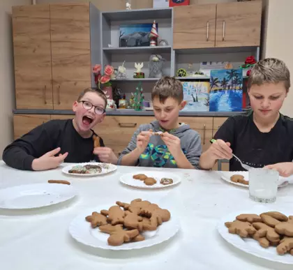 Chłopcy lukrują upieczone pierniki.