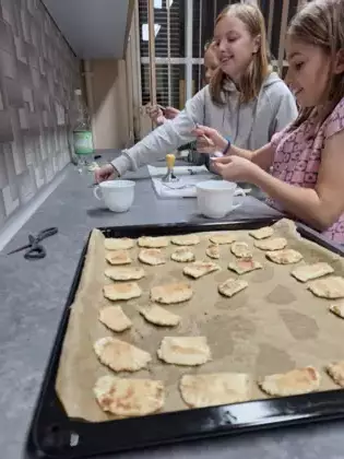 Uczestniczki zajęć pieką ciasteczka z wróżbą w środku.