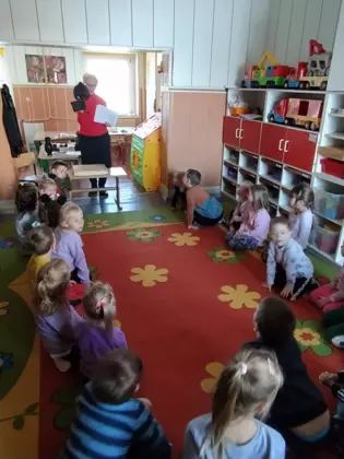 Pani bibliotekarka pokazuje dzieciom w przedszkolu strój górnika.
