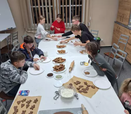 Dzieci pieką pierniki na zajęciach w bibliotece.