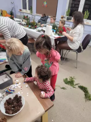 Uczestnicy zajęć wykonują swoje stroiki świąteczne.
