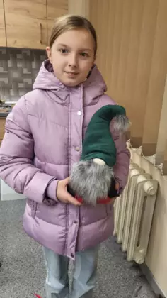 Dziewczyna trzyma w ręce uszytego krasnala.