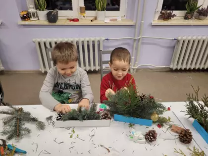 Uczestnicy wykonują swoje stroiki świąteczne.