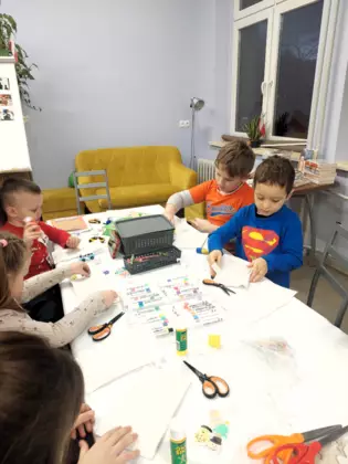 Dzieci w trakcie robienia papierowej gwiady.