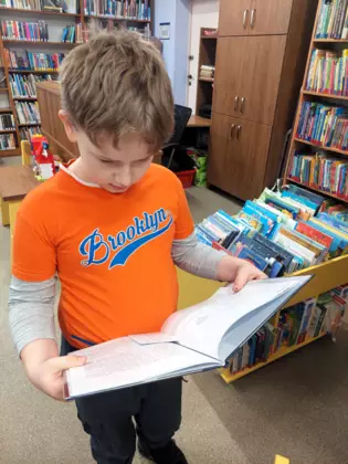 Chłopiec przegląda świąteczną książkę.