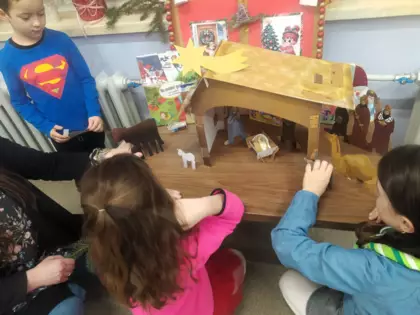 Dzieci układają Stajenkę Betlejemską.