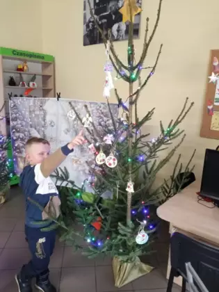chłopczyk wskazuje anioła na choince
