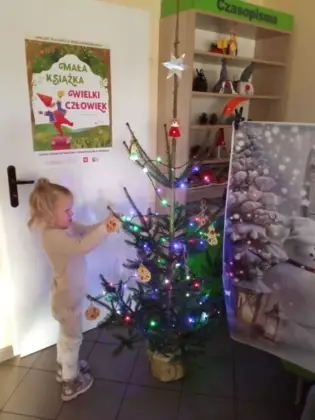 dziewczynka wiesza ozdoby na choince