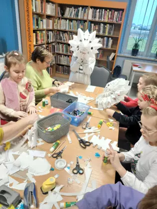 Uzestnicy zajęć dochodzą do finału i tworzą z torebek papierowych gwiazdy.