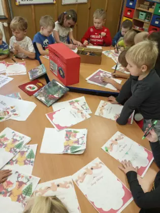 Przedszkolaki kolorują obrazki do Świętego Mikołaja