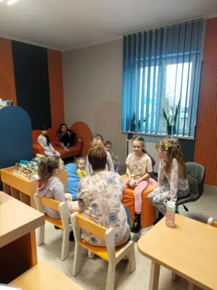 Pani bibliotekarka czyta dzieciom książeczkę.