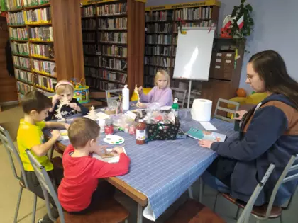 Dzieci malują choinki i słuchają wiersza pt. Choinka.